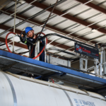 Worker on gangway inspecting railcar, Soltex Safety Committee