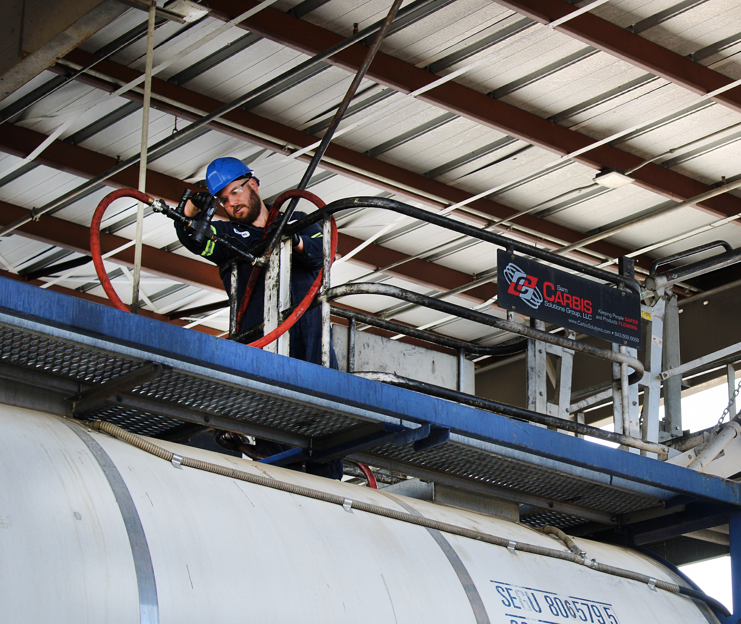 Worker on gangway inspecting railcar, Soltex Safety Committee